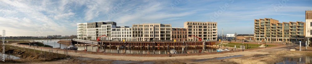 Super wide view of Noorderhaven recreational port with small boats in the foreground and new luxury apartment building