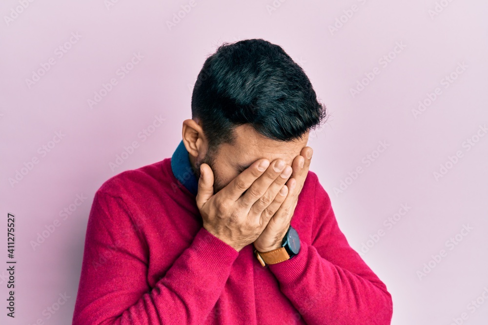 Young hispanic man wearing casual clothes with sad expression covering face with hands while crying. depression concept. Young hispanic man wearing casual clothes with sad expression covering face with hands while crying. depression concept.