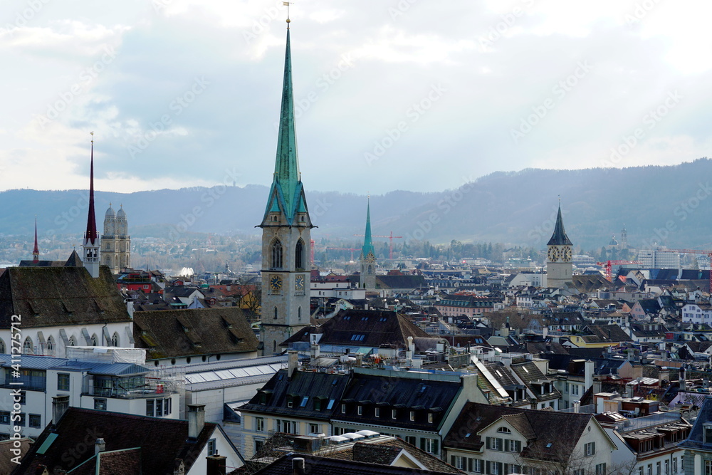 Zurich, Switzerland - 03 12 2020: Panorama of Zurich historical center. Church towers are high above the rooftops, Predigerkirche, green tower in the foreground. Panoramic view in of the old city.