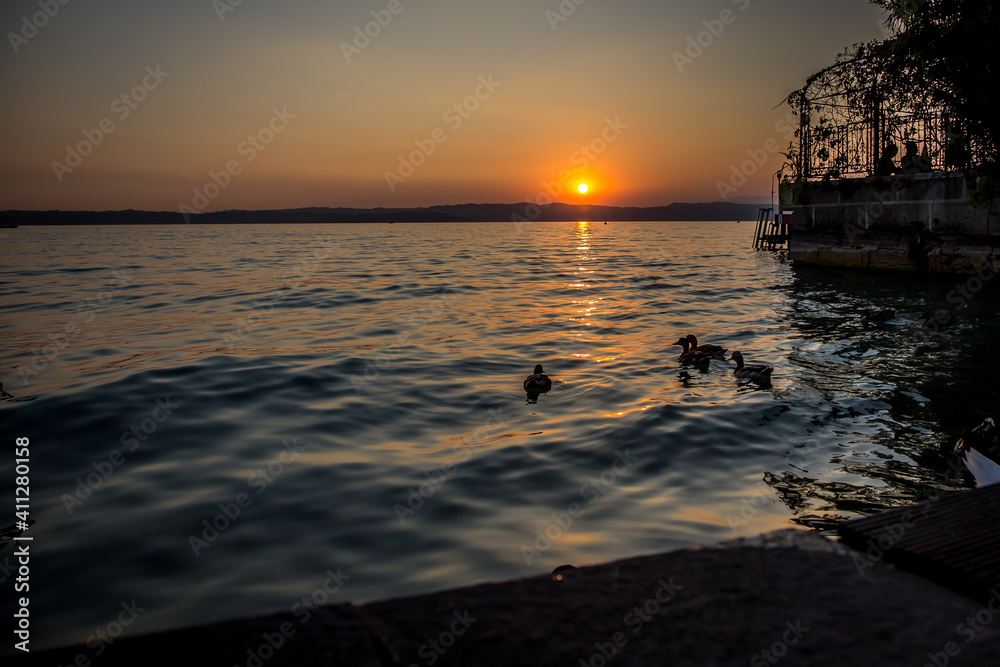 Sunset on over Lake Garda. A beautiful autumn evening. The sun sets below the horizon. Sirmione, Lombardy, Italy