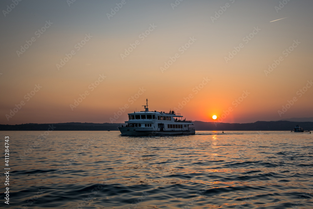 Fototapeta premium Passenger ship on the background of the sunset on Lake Garda. Lombardy, Italy