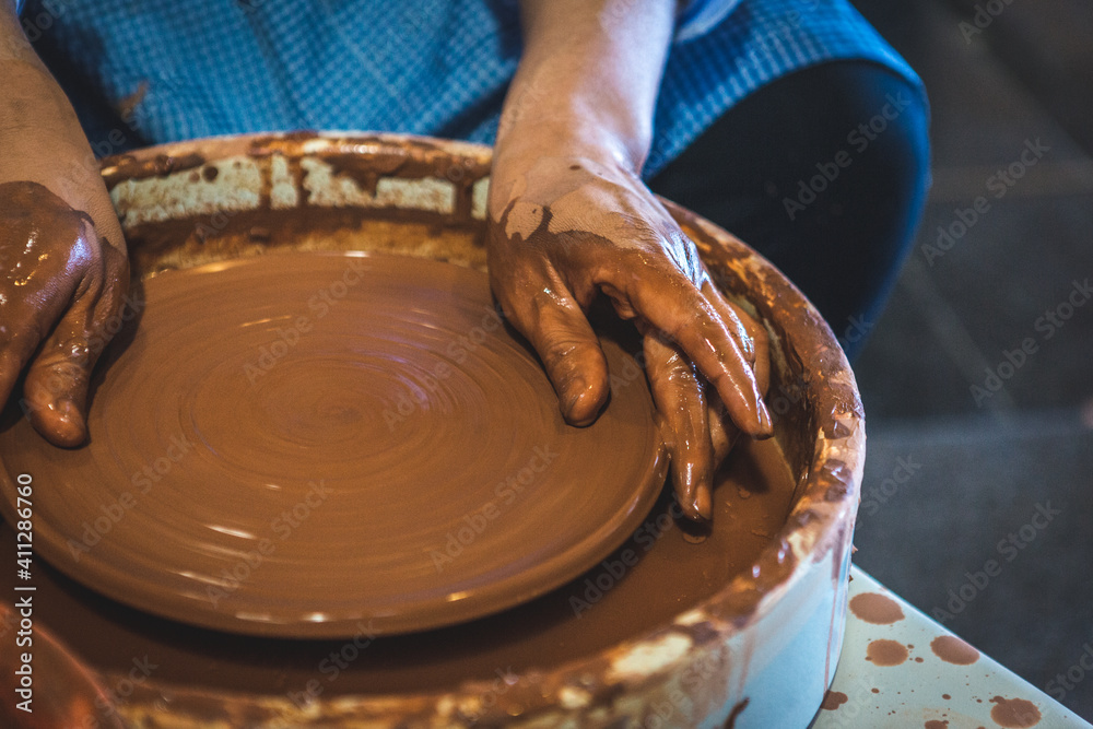 Fototapeta premium Pottery workshop, where it is shown how the master makes a plate from clay