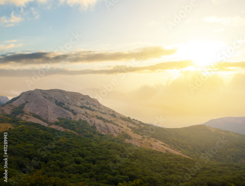 mountain silhouette in dense mist at the dramatic sunset, natural travel background