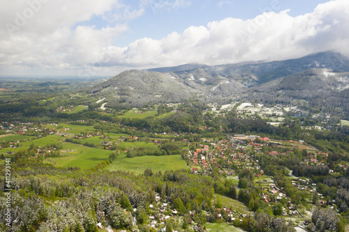 Mountains in the Czech Republic in spring with green fields and snow in the mountains 