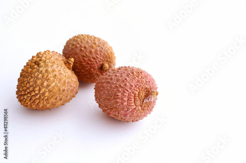 lychee fruits inside a black bowl grouped on white background, isolated, close up photo