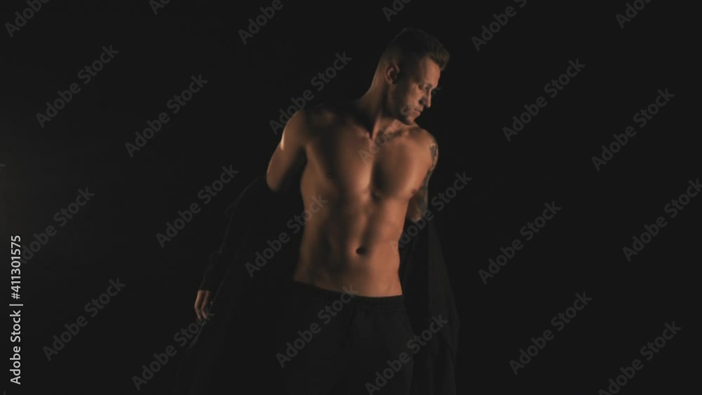 Sexy man in black cardigan on black background