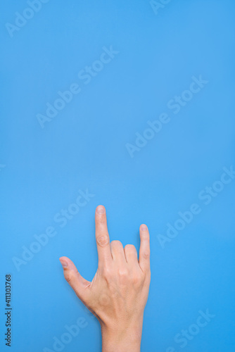 hand of a caucasian man doing symbol of love with a blue background