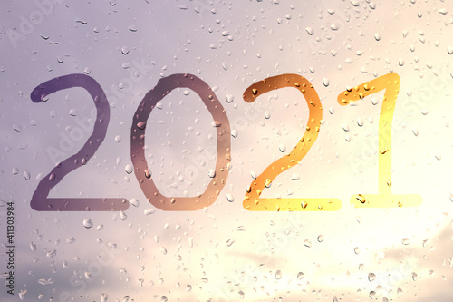 2021, the inscription on the glass with raindrops in the sunset light.