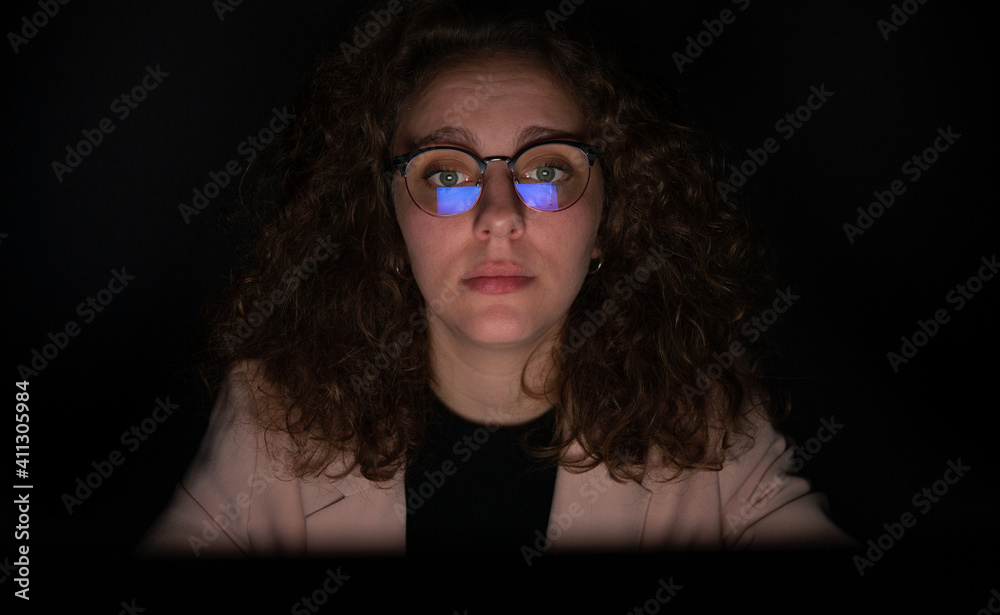 Woman working at night with computer and reflection of screen in the glasses. Woman working at night with computer and reflection of screen in the glasses.