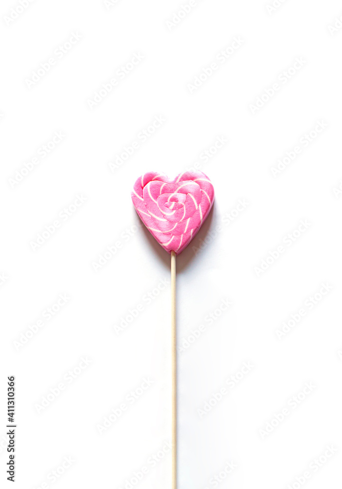 Heart shape pink lollipop on the white background. Valentine's day greeting card	