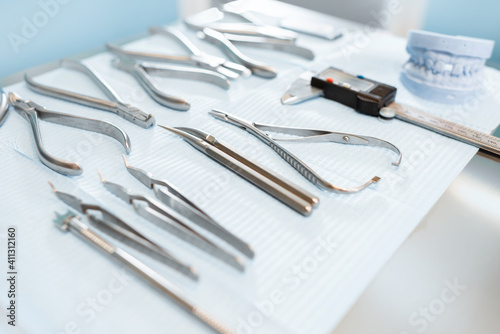 Dental tools and artificial jaw model for the orthodontic treatment lying on the table at the dental office, close-up. High quality photo