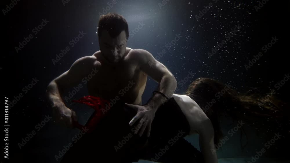 man is whipping with whip his girlfriend floating underwater, bdsm sex practice in swimming pool