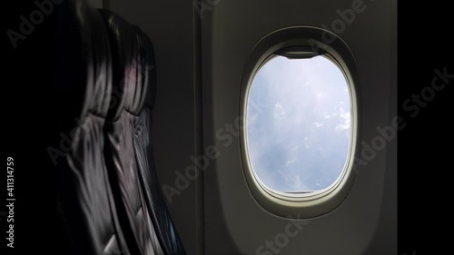 Cloudscape. Blue sky puffy fluffy white clouds time lapse. View from window of passenger seat in cabin on commercial airplane. Transportation and travel concept. Airplane flight.