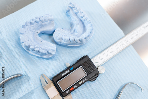 Dental tools and artificial jaw model for the orthodontic treatment lying on the table at the dental office, close-up. High quality photo photo