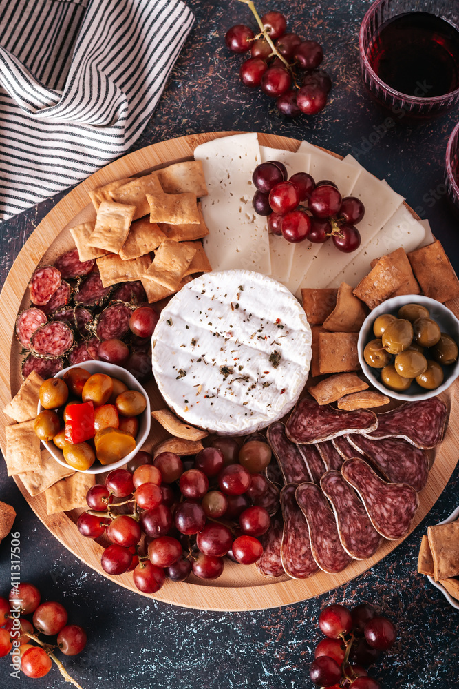 Mediterranean charcuterie board with various kinds of snacks for sharing on concrete background, top view
