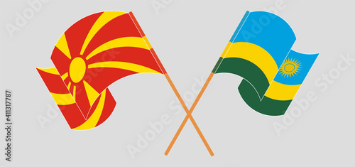 Crossed and waving flags of North Macedonia and Rwanda