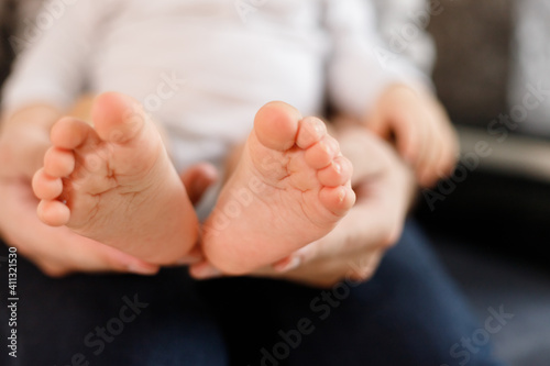Father's hands carefully keeping baby's feet with tenderness © vladdeep