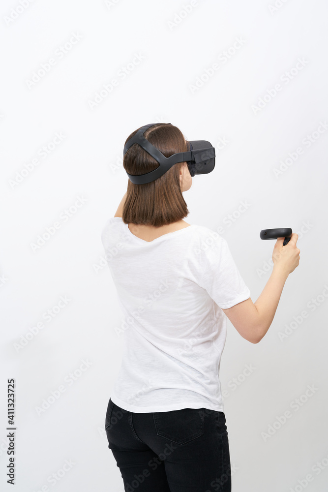 Young woman in white short in virtual reality (VR) glasses. New generation wireless headset and system.  Isolated on white background