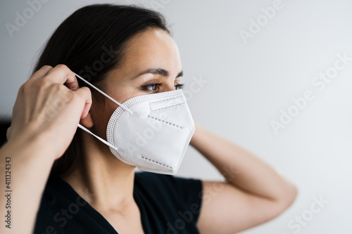 Woman Putting On Medical Face Mask photo