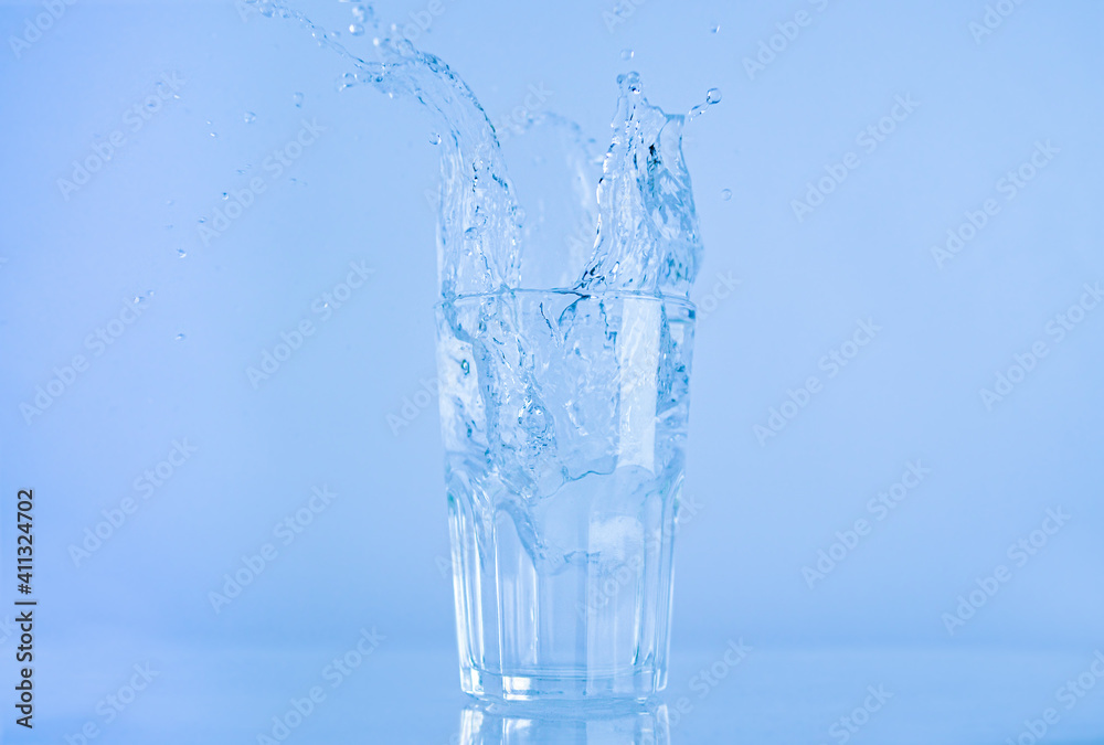A glass of water splashed up. The water rose from a clear glass with a square. A glass of water splashed up. The water rose from a clear glass with a square.