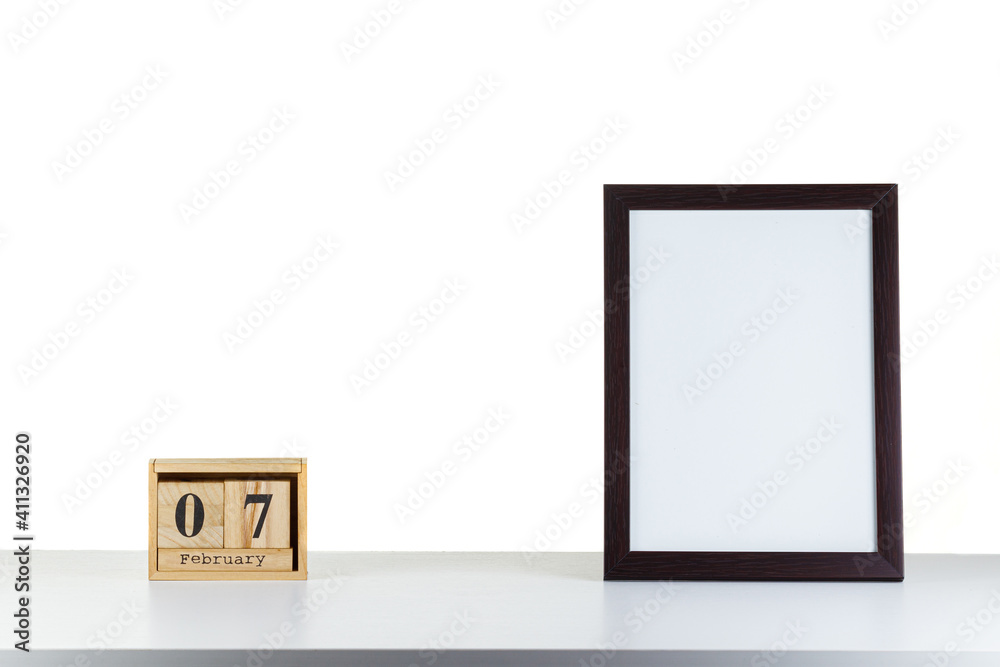 Wooden calendar 07 february with frame for photo on white table and background Wooden calendar 07 february with frame for photo on white table and background