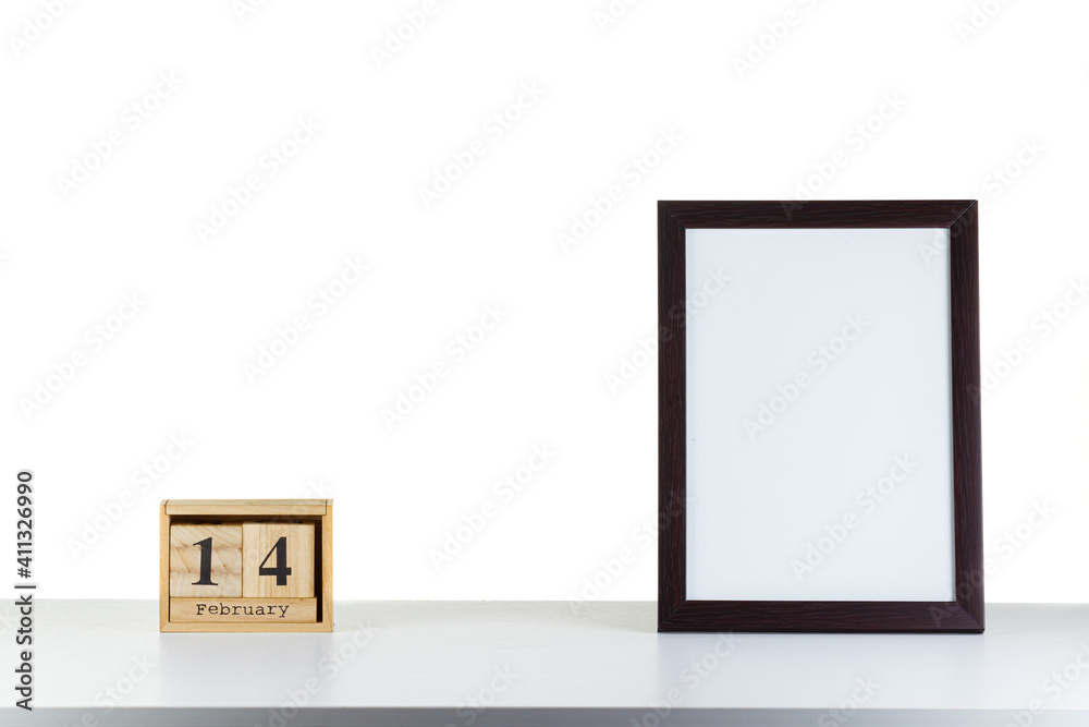 Wooden calendar 14 february with frame for photo on white table and background Wooden calendar 14 february with frame for photo on white table and background
