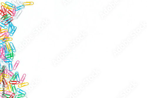 Stationery multicolored paper clip on white background. Place for your text.