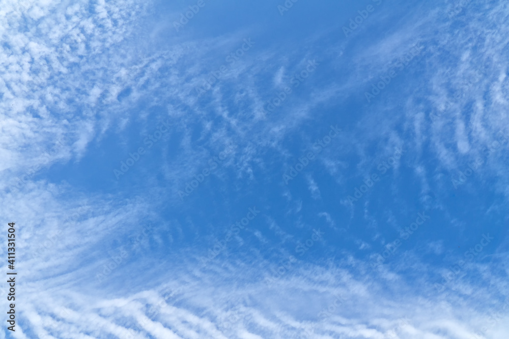 Blue sky with white, soft clouds. Natural white and blue background. The texture of the clouds.