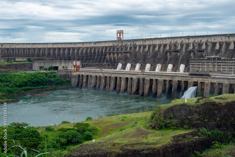 Foz do Iguaçu, Brazil - January 26, 2021: Panoramic view of the Itaipu hydroelectric plant with water gushing through the floodgates. Clean and renewable energy.