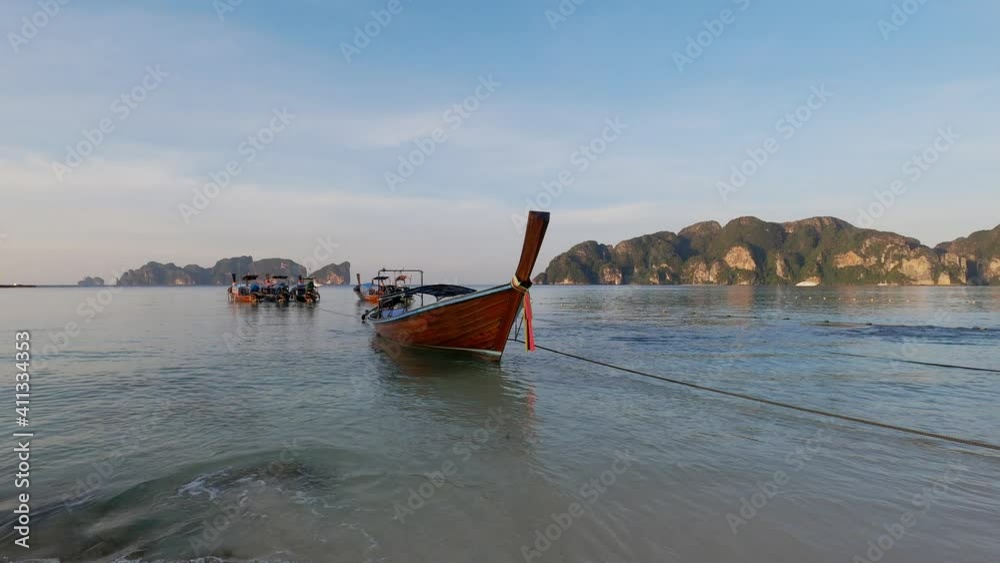 Traditional long tail boats soaring on a calm andaman sea with islands on a horizon on Phi Phi Islands, Thailand. Traditional long tail boats soaring on a calm andaman sea with islands on a horizon on Phi Phi Islands, Thailand.