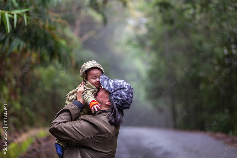 Happy family mother and baby hugging in Nature rainforest. Happy harmonious family outdoors. Happy family mother and baby hugging in Nature rainforest. Happy harmonious family outdoors.