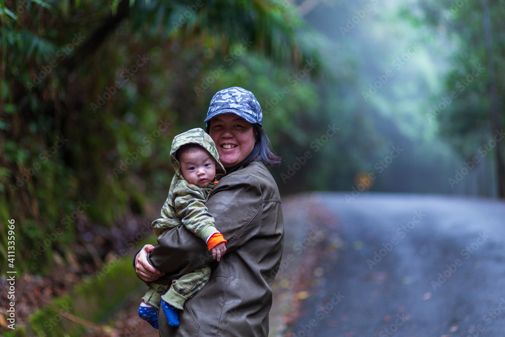 Happy family mother and baby hugging in Nature rainforest. Happy harmonious family outdoors. Happy family mother and baby hugging in Nature rainforest. Happy harmonious family outdoors.