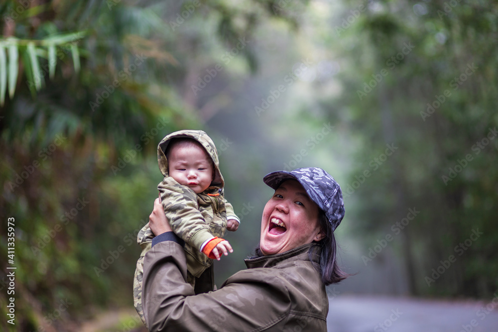 Happy family mother and baby hugging in Nature rainforest. Happy harmonious family outdoors. Happy family mother and baby hugging in Nature rainforest. Happy harmonious family outdoors.
