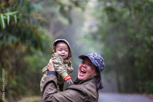 Happy family mother and baby hugging in Nature rainforest. Happy harmonious family outdoors.