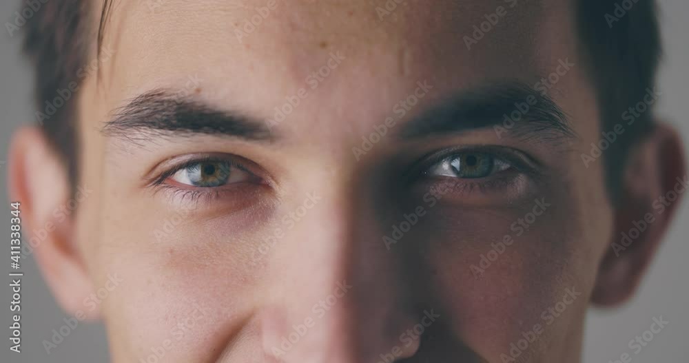 Close up portrait of caucasian male's eyes opening before smiling to camera, in slow motion Close up portrait of caucasian male's eyes opening before smiling to camera, in slow motion