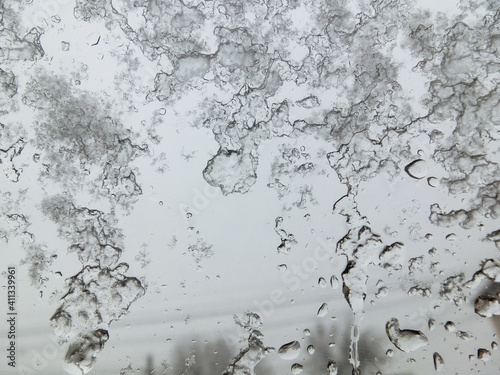 Snow melts on glass