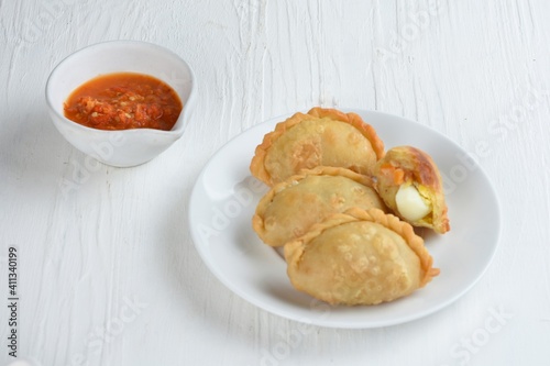 Pastel Goreng is Pastry Popular in Indonesia. fried pastry with filling of sautéed vegetable , chicken and boiled egg. accompanied with sauce or raw chilli pepper
