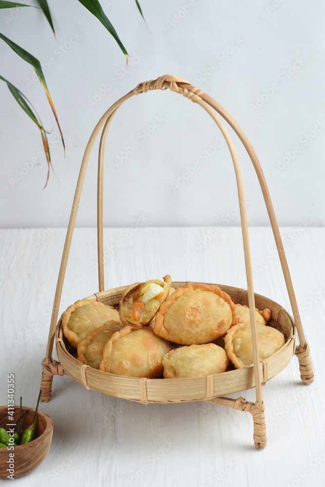 Pastel Goreng is Pastry Popular in Indonesia. fried pastry with filling of sautéed vegetable , chicken and boiled egg. accompanied with sauce or raw chilli pepper

