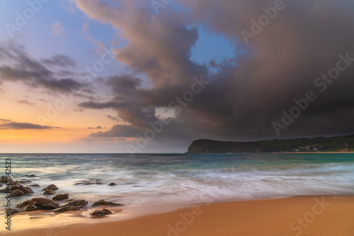 Sunrise at the seaside with rain clouds rolling in