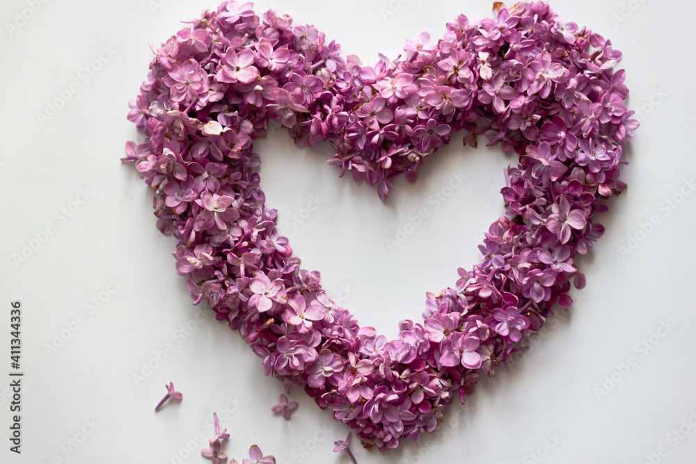 Heart of spring flowers of lilac on a white background. Love symbol for Valentine's Day. Mother's Day. Spring, women's day. Particles of art. Heart of spring flowers of lilac on a white background. Love symbol for Valentine's Day. Mother's Day. Spring, women's day. Particles of art.