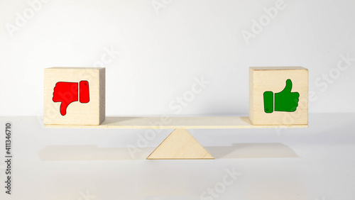 mock up miniature wooden blocks of thumbs up and thumbs down concept of like and dislike.