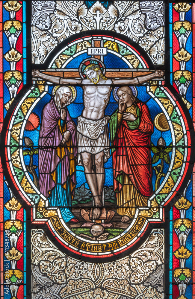 VIENNA, AUSTIRA - OCTOBER 22, 2020: The Crucifixion on the stained glass in  in church Pfarrkirche Kaisermühlen by workroom Tiroler Glasmalerei-Anstalt from end of 19. cent..