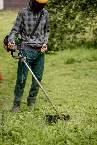 Man mowing the lawn in his garden. Gardener cutting the grass. Lifestyle.