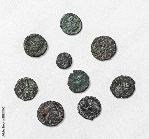 Selection of generic ancient dirty coins arranged against a textured white background.