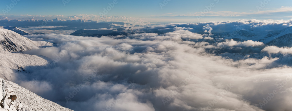 Fototapeta premium View from the top of the mountain valley covered with clouds