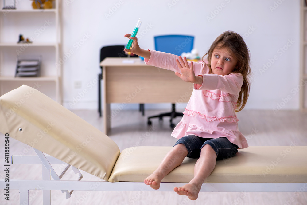 Small girl holding syringe waiting for doctor in the clinic Small girl holding syringe waiting for doctor in the clinic