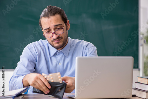 Young sick male teacher in the classroom