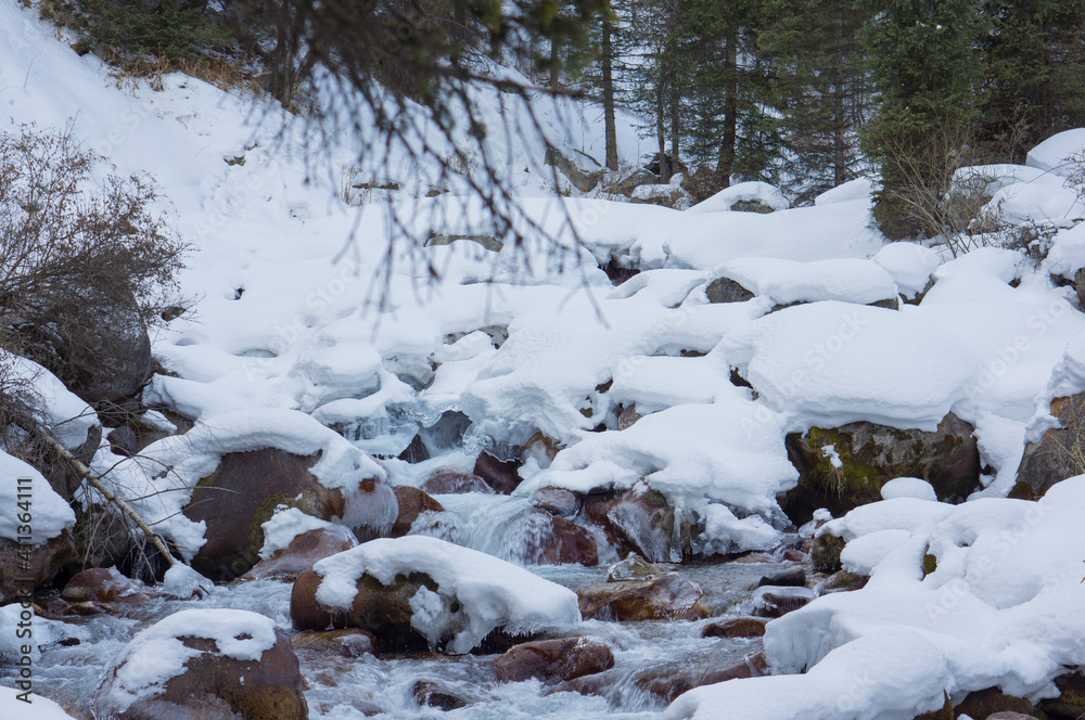 Mountain river among stones and snow. Mountain river among stones and snow.