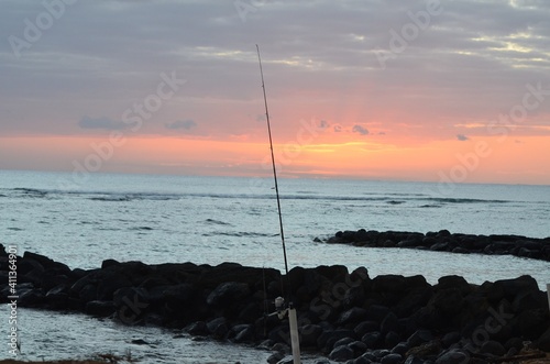 Fishing in the early morning, with a beautiful sunrise on the horizon
