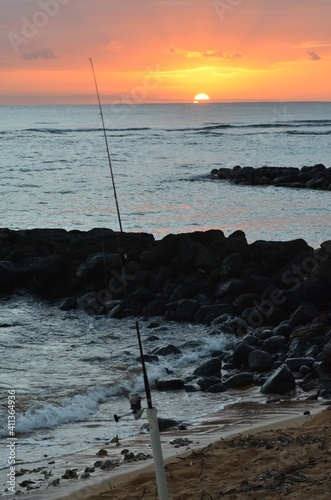 Fishing in the early morning, with a beautiful sunrise on the horizon
